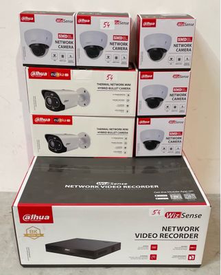 Plusieurs cartons contenant des caméras de surveillance sont empilés les uns sur les autres