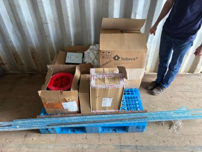 a man standing next to a pile of boxes on a pallet