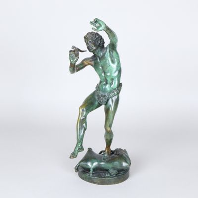 statue en bronze représentant un homme tenant un oiseau, sur fond blanc