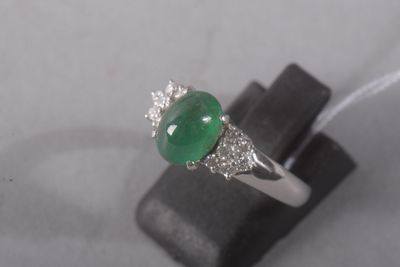 an image of a ring with a green jade and diamonds