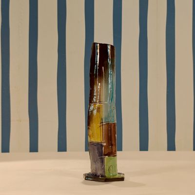 a vase that is sitting on a table in front of a striped wall