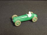 a green toy car that is sitting on a black surface