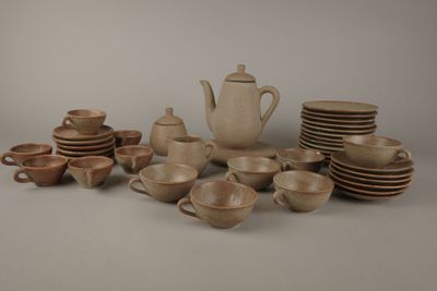 plusieurs tasses et soucoupes et une théière sur la table