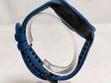 a close up of a blue watch on a clear stand
