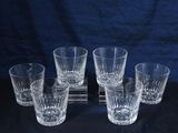 six verres de tailles et de formes différentes posés sur une surface noire