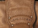 leather handbag with a leather tag on the front of it
