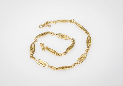 un ensemble composé d'un collier et d'un bracelet plaqués or, sur fond blanc