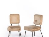 two wooden chairs sitting next to each other on a white surface