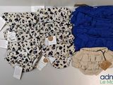 two pairs of baby diapers and a diaper cover on a table