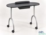 the computer desk has a black top and wheels on it