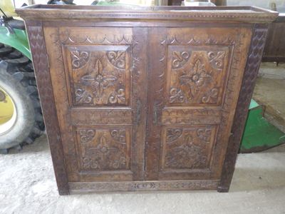 une armoire en bois ornée de sculptures, dans un garage