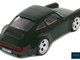 a green toy car that is sitting on a white surface