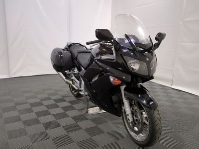 une moto noire garée sur un sol à damier