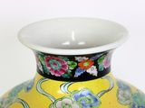 a yellow vase with a floral design on it