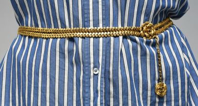 un gros plan sur la ceinture d'une femme ornée d'une chaîne en or