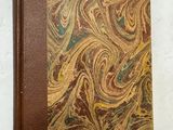 un vieux livre à la couverture brune posé sur une table