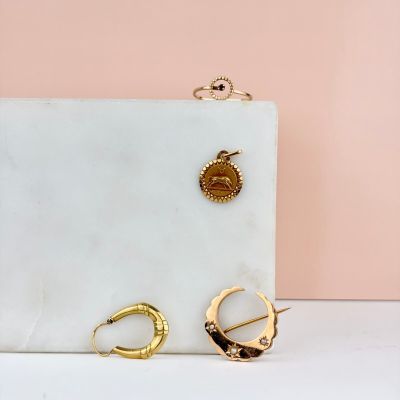 a close up of a pair of earrings on a marble surface