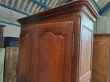 a large wooden armoire in a room with a lot of furniture