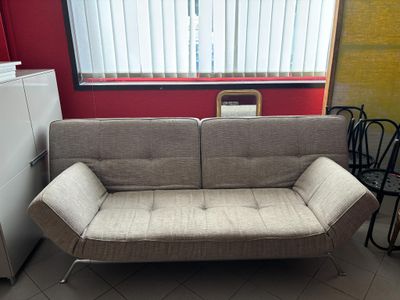 a couch that is sitting in a room next to a refrigerator