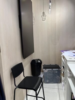 a black chair in the corner of a small room