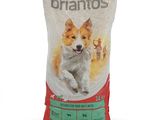 un sac blanc de croquettes pour chien sur lequel est assis un chien brun