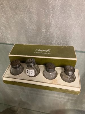 three salt and pepper shakers on display in a glass case
