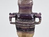 a purple vase that is on a stand on a white background