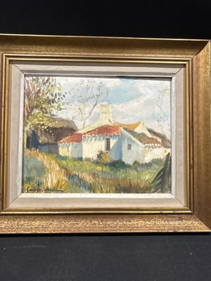 une peinture à l'huile représentant une maison blanche au toit rouge, dans un cadre doré