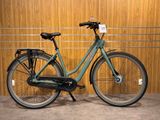 un vélo vert garé devant un mur en bois