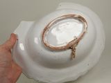 a person holding a white bowl with a gold rim