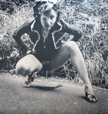 photographie en noir et blanc d'une femme sur un skateboard au milieu de la route