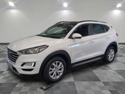 un SUV blanc garé dans un garage au sol carrelé