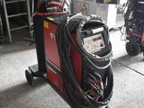 une soudeuse dans un garage, à côté d'autres équipements