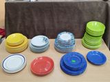 beaucoup d'assiettes colorées posées sur une table dans une pièce