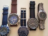 Plusieurs montres différentes sont alignées sur une table