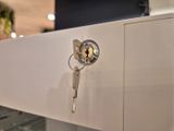 un gros plan d'une clé posée sur une armoire blanche