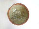 a green bowl sitting on a table with a white background