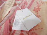 a tag on a pink and white dress with a pink flower pattern