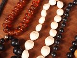 many different colored beads on a table with a phone
