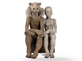 une statue représentant un homme et une femme assis sur une chaise