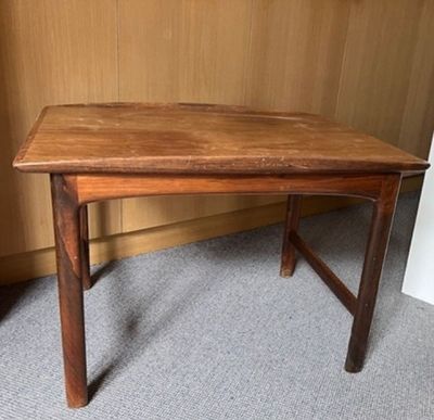 une image représentant une table en bois posée sur un sol recouvert de moquette