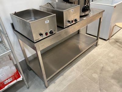 two stainless steel sinks sitting on a table in a kitchen