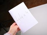 a person holding a piece of paper with the word laxx written on it