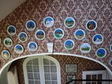 de nombreuses assiettes accrochées au mur au-dessus d'un lit dans une chambre