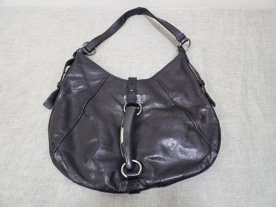 the large black purse is sitting on a white surface