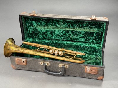 a brass trumpet in a green case on a table