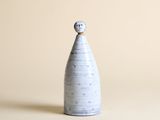 un vase blanc surmonté d'une boule