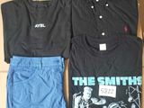 two shirts and a pair of shorts sitting on a cardboard box