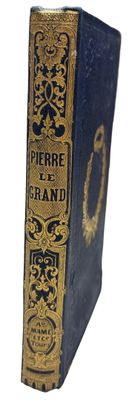 an old blue book with gold trim sitting on top of a white surface