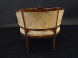 an old fashioned chair with a wooden frame and upholstered back